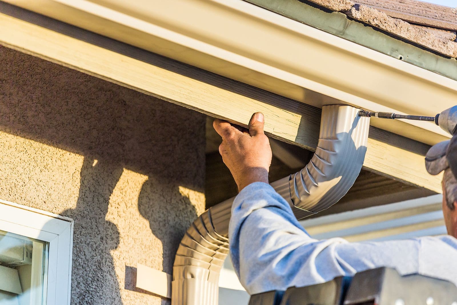 A worker installs new gutters.